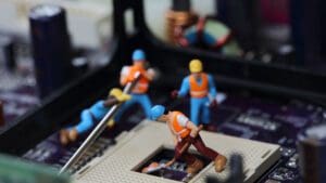 Little construction figures placed on circuit board as if working on it