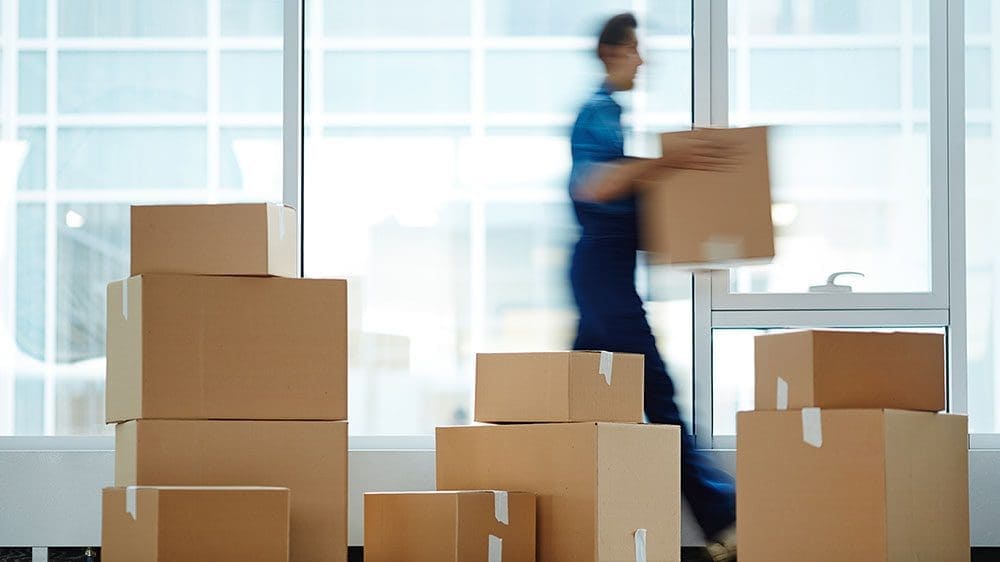 Stacked boxes and man carrying a box