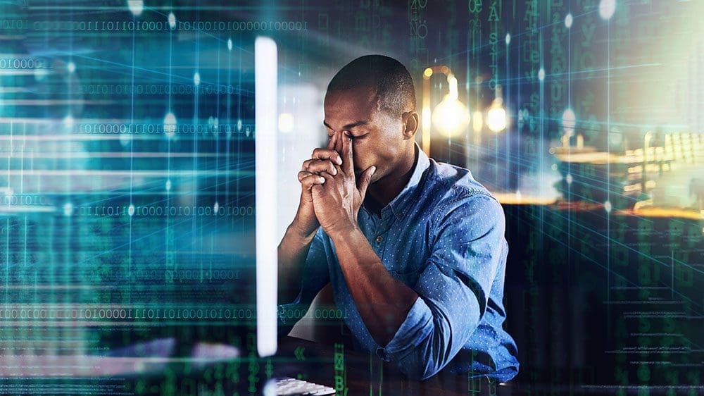 Stressed out man at work place who looks like he has a headache